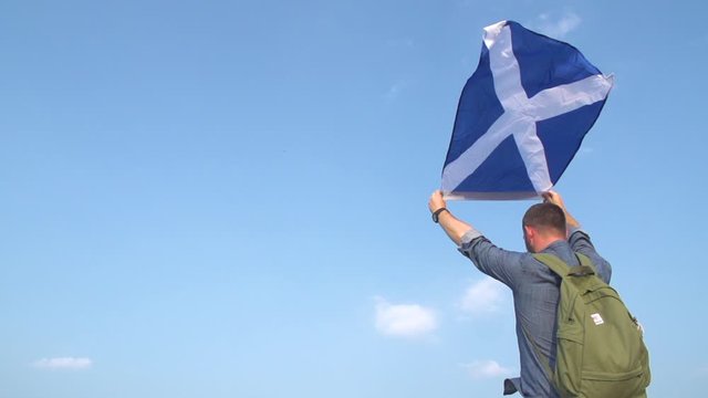 Man holds scottish flag in the wind in slow motion 200 fps