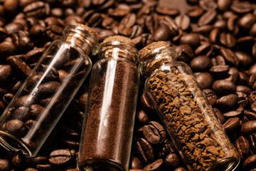 Ground coffee and instant coffee in flasks on a background of roasted coffee Grains