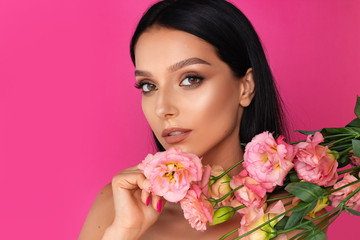 Fototapeta premium a beauty brunette woman portrait,a pink flower in the hand
