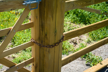 Wooden gate closed with metal chain