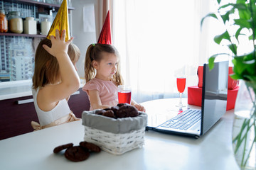 Kids virtual birthday party.Girls in dresses and caps celebrate holiday with friends on...