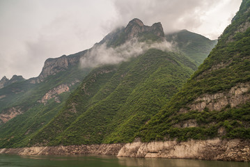 Wushan, Hubei, China - May 7, 2010: Wu Gorge in Yangtze River. Gray cloudscape descends along green...