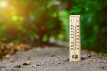 wood thermometer calibrated in degrees celsius and fahrenheit in sweltering day. - concept of...