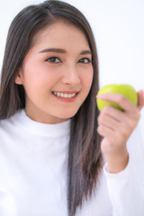 Close up Young Asian smiling woman  holding green apple on hand.