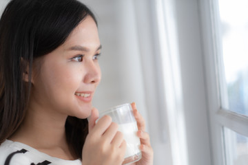 Young beauty Asian woman drink milk and smile