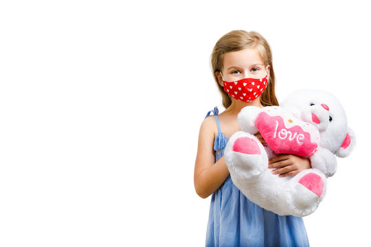 A Child With Red Face Mask Hugs A Teddy Bear. Isolated On White Background. Copy Space.