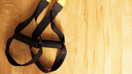 Closeup view of suspension on wooden background training at home - Fitness at home