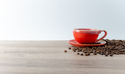 Coffee in a red ceramic cup on a light wooden table. Background menu in the coffee shop, relaxing time holidays. 