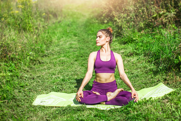 A happy young beautiful woman in sportswear doing fitness in nature. Healthy lifestyle and outdoors fitness concept. Fitness and activity. Copy space.