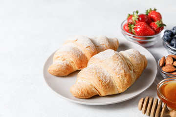 Breakfast with fresh croissants and berries on white table background