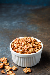Homemade oatmeal granola bowl on dark background.
