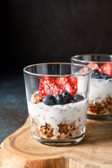 Granola parfait with oat cereal, fresh berries and greek yogurt in glass