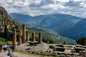 Delphi, Phocis / Greece. The famous Temple of Apollo at the archaeological site of Delphi town, with a beautiful panoramic view of the nature on a sunny day with cloudy sky.