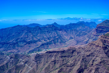 Hiking in Mountain Scenery of Gran Canaria Island - Mountain Teide of Tenerife Island  in the background - beautiful landscape scenery - travel destination in Spain