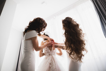 Hands of bridesmaids on bridal dress. Happy marriage and bride at wedding day concept