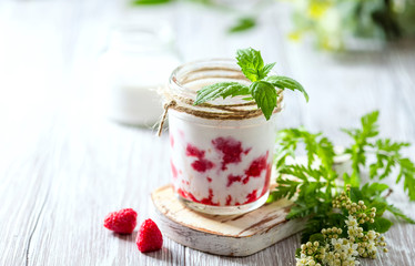 Raspberry smoothie, milkshake in a glass jar on a light background. Yogurt cocktail. Natural summer detox drink.