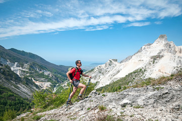 panoramic landscape of a man trekking over the white marble quarries of Carrara