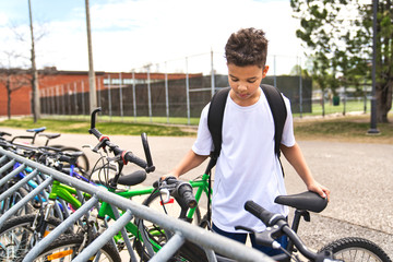 boy riding bike wearing a helmet outside at school playground