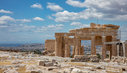 Fototapeta na wymiar Athens, Greece. Propylaea in the Acropolis, monumental gate, blue cloudy sky in spring sunny day.