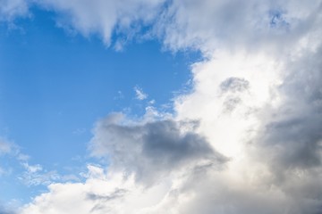 White and gray fluffy clouds in the blue sky. Beautiful sky background