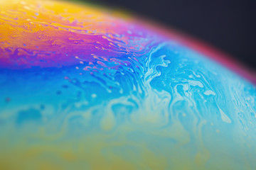 Abstract iridescent rainbow wave background on a sphere surface. Soap bubble texture