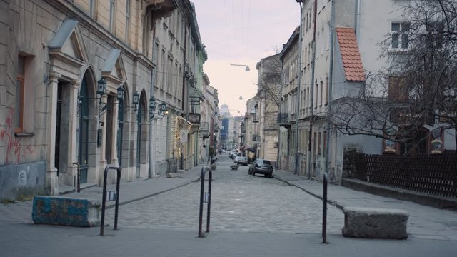 View at empty cozy old street in antique European town. Small alley in city with beautiful old architecture on cloudy day. Buildings in the downtown. Lockdown time concept.