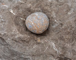 Round stone - a large sea pebble lies in a recess of the rock.