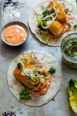Fish tacos with cod, harrisa sauce, pickled onions and chili