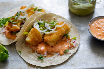 Fish tacos with cod, harrisa sauce, pickled onions and chili