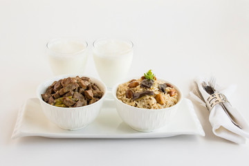 Traditional Turkish Islamic Feast,braised meat and rice in stylish white bowls on the white surface with fabric napkin and cold drink.