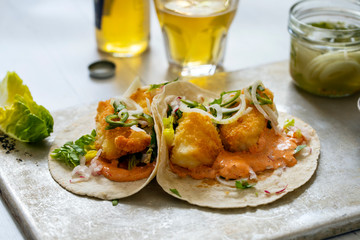 Fish tacos with cod, harrisa sauce, pickled onions and chili