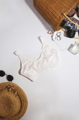 Woman bra on white background. Fashion trendy lace lingerie, sunglasses, straw hat and bag. Beautiful clothing. Women's underwear. Top view, flat lay. Female wardrobe, shopping concept