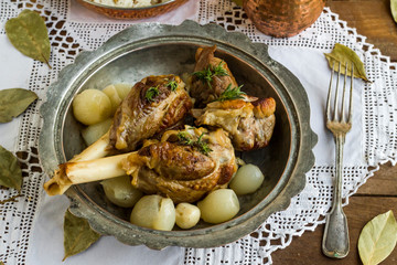 Lamb shank,rice and buttermilk drink,served on wooden table with handmade lace tablecloth and old vintage copper dishes.Traditional Islamic Feast or any holiday concept.