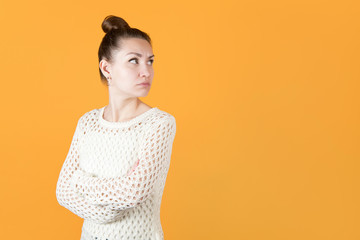 girl with resentment looks at someone over her shoulder, hands clasped on her chest