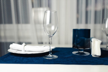 Table setting with empty glass empty plate on white window background