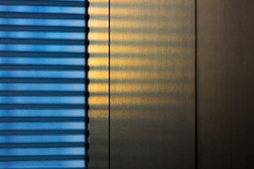 Sunlight streaming through blinds on wall at office