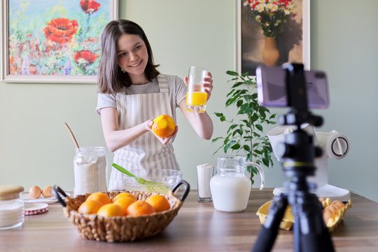 Girl teenager food blogger recording recipe for cooking orange pancakes