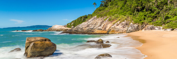 Fototapeta na wymiar Tropical beach with panoramic views and waves, rocks and sand background. Travel destinations in Brazil and banner web.