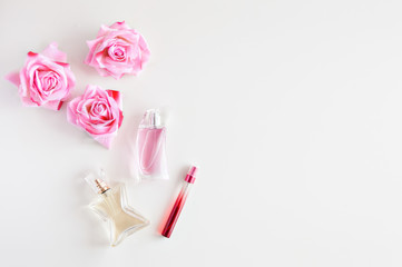 Real photo of perfume with rose flowers on a white background. Empty space for insertion.