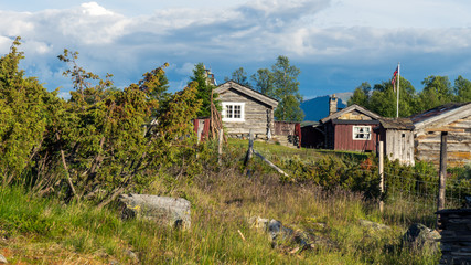 Cabins and old farmhouse in Rondane national park in Norway with golden light.