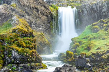 Green and colorful waterfall scenery with textured moss, clear and fresh water, cacades and landscape details.