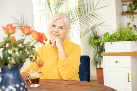 Smiling senior woman with hot coffee.