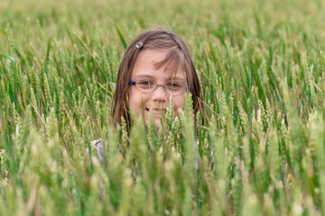 Cute girl farmer in wheat field. Portrait of a girl in a wheat field.