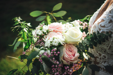 Closeup view of colorful wedding bouquet. Bride holding bunch of flowers. Outdoor background. Wedding day concept.