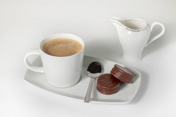 Cup of coffee with milk and chocolate cookies isolated