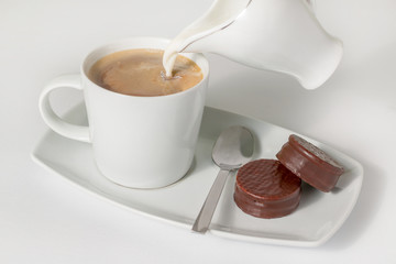 Cup of coffee with milk and chocolate cookies isolated