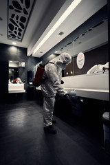 cleaning the surfaces of a building using special protective clothes and disinfection equipment