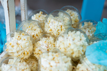 Crunchy and tasty salted popcorn in plastic containers