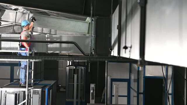 Air Ventilation Caucasian Technician in His 3o with Flashlight Looking For Potential Issues with the Heating, Cooling and Air Filtering System. Vent Shafts.