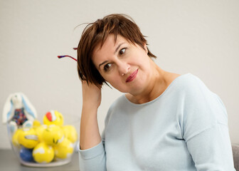 The woman psychologist wearing a blue blouse and black glasses smiling, thinking and sitting in an office